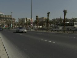 WS PAN  office tower at end  road cars streaming on highway /  Manamba,Bahrain Stock Footage