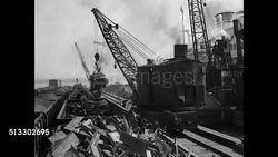 1937: U.S. METAL JUNK YARD: WS Magnetic crane lifting metal scraps from junk yard. MS Magnetic crane over junk. WS Ship in dock w/ Japanese flag. MS Net carrying crushed metal cubes, worker. WS Multiple cranes lifting junk to ship. Instructional Video