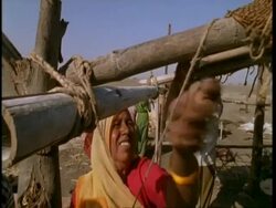 MCU High angle, Woman sewing canvas to roof of house, Gujarat, India Stock Footage