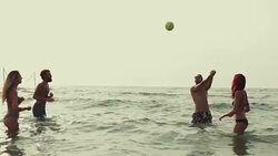 Friends play beach volley in the sea Stock Footage