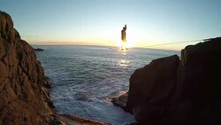 Man traverses highline stretched above sea below Stock Footage