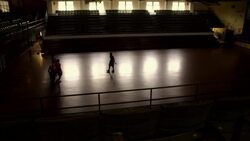 Four men play basketball together in a dark gymnasium. Stock Footage