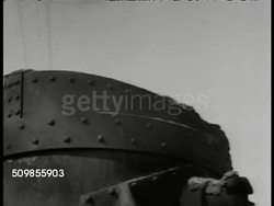1943: MEXICO WAR PRODUCTION, STEEL: WS Train pulling barrel, steel mill, factory BG. WS Mexican workers pouring steel, fire, molten. CU Molten pouring out, sparks. VS Workers shoveling coal into furnace. WS Bessemer tilting, fire. WWII Instructional Video