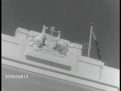 1941: OLD PARLIAMENT HOUSE: Provisional Parliament House w/ men walking on lawn. Australian Coat of Arms near roof. INT House of Representatives chamber. WS Speaker seated in wig & gown. Member in wig & gown reading from paper. (could also be Senate) Instructional Video