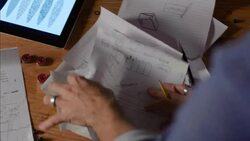 Worker flips through papers on desk in wood shop Stock Footage