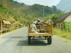 MS SLO MO Shot of small moving open truck with man sitting in back / Road from Luang Prabang to Nong Khio, Luang Prabang, Laos Stock Footage