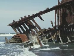 MS SLO MO Shot of Old rusted shipwreck of Peter Iredale is sunk in high tide off Oregon coast / Astoria, Oregon, United States  Stock Footage