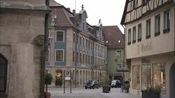 A few vehicles park in front of quaint shops in Frankfurt, Germany. Stock Footage