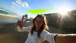 Young woman takes a selfie portrait on Gibsons steps beach Stock Footage