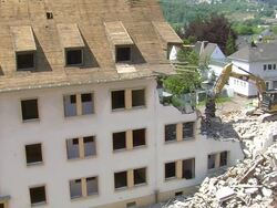 MS Two bulldozers at demolition of apartment block / Saarburg, Rhineland-Palatinate, Germany Stock Footage