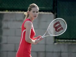 CU of a female tennis player as she hits the tennis ball backhand. Stock Footage
