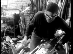 Richard Hunt, the sculptor, at work in his studio in Chicago. Neighbourhood boys watch. 1965 Stock Footage