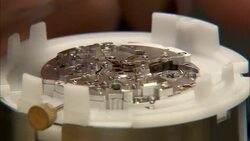 A technician uses tweezers and a tiny screwdriver to assemble a mechanical watch. Stock Footage