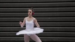 Cool young ballerina leaping and listening to music with headphones and mp3 player Stock Footage