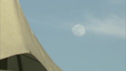 A full moon glows in a blue sky above white tent peaks in Saudi Arabia. Stock Footage