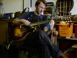 Craftsman 'Luthier' Nigel Forster making hand made Guitars Stock Footage