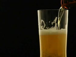 Refreshing beer into rotate glass in the dark night Stock Footage