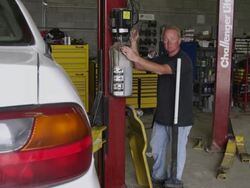 Slow motion shot of a mechanic at a car lift. Stock Footage