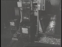 Workers sort coins on a conveyor belt after machinery makes the coins. News Clip