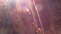 Close up of rappelling rope and hands as slowly lowering to canyon floor with sun-flare (POV) Stock Footage