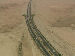 WS AERIAL PAN Shot of electricity pole and traffic moving on highway in desert / Qatar Stock Footage