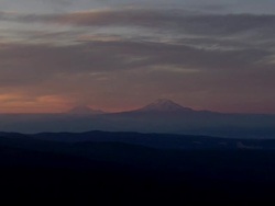 Mount Hood in a painterly shroud of pink and orange clouds at sunset Stock Footage