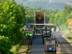 WS HA Shot of two steam roller with dumper and workers working on re surfacing of road / Saarburg, Rhineland-Palatinate, Germany Stock Footage