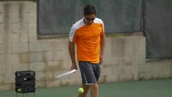 Male tennis player gathering tennis balls with racket.  - Slow Motion Stock Footage