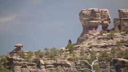 Desert rock formations contrast against a pale blue sky. Stock Footage