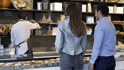 Couple ordering from the bakery counter and salesman serving Stock Footage