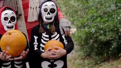 Children in skeleton costumes holding pumpkins Stock Footage