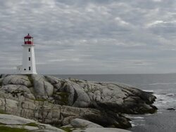 WS PAN View of lighthouse on rock at ocean / Peggys Cove, Nova Scotia, Canada Stock Footage