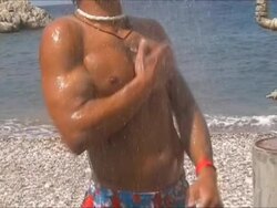 Torso of young man having shower at the beach Stock Footage