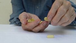 Senior adult holding a medicine pill in his hands. Stock Footage
