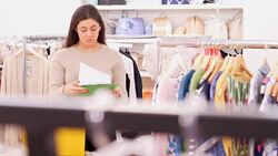 Clothing shop owner with clipboard checking inventory Stock Footage