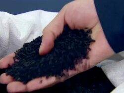 Close Up hand-held - A hand pulls bits of black rubber out of a sack./Shanghai, China Stock Footage