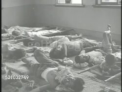 MOT 1950: KOREAN WAR: VS South Korean refugees walking w/ bags & personal belongings on rural road. VS Injured & wounded soldiers lying on floor mats, female nurse preparing bandage wrapping, young male lying down w/ wrapped broken arm. Instructional Video