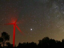 Time lapse of a wind turbine with the Milky Way. Satellites are visible momentarily before they disappear when entering the Earth's shadow located just above the horizon. Jupiter is the brightest star in the field Stock Footage