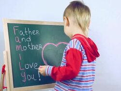 boy draws a card for parents Stock Footage