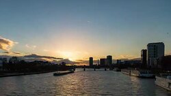 A winter sunset of the Main river from the Eiserner Steg (Iron Footbridge) in Frankfurt am Main, Germany, showing barge and ferry traffic on the water and clouds moving towards the camera Stock Footage