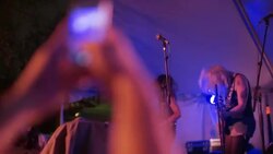 Fan takes smartphone photo of band at outdoor rock concert Stock Footage