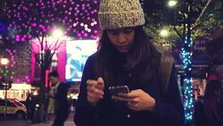 Female using smart phone in city at night Stock Footage