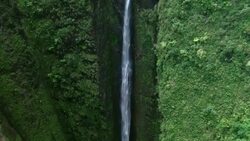 Aerial view of Sacred Falls, tilting down to reveal the pool at the bottom of a deep well. Stock Footage