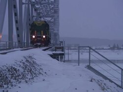 Wide Shot pan-left - A train engine crosses a truss bridge. / Yakutsk, Russian Federation Stock Footage