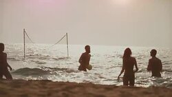 Friends play beach volley in the sea Stock Footage