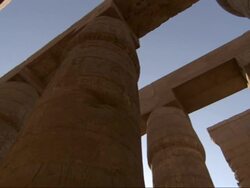 Low Angle, pan-left - Carvings of hieroglyphs cover the columns of ancient adobe buildings / Egypt Stock Footage