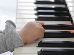 HD : Mother playing a piano with her baby Stock Footage