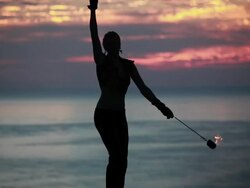 MS Woman poi dancers silhouette performing with fireballs in front of sunrise and ocean / Montezuma, Costa Rica Stock Footage