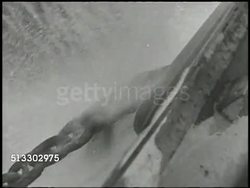 1943: BOUGAINVILLE CAMPAIGN: VS Male w/ flags signaling craft, anchor chains being pulled up, fleet of U.S. Navy transport & battleships setting sail in Pacific Ocean. WWII, World War II, Pacific Front, mobilizing Instructional Video