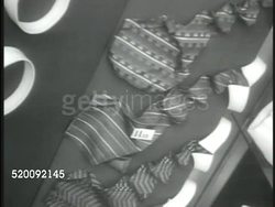 1935: MOSCOW, USSR, SOVIET UNION: Shop window displays of undergarments, ties, men's collars. VS Consumers, woman looking at dresses, crowded check-out counter, CU Russian paper money, cashier making change. Russia, Communism, propaganda. Instructional Video